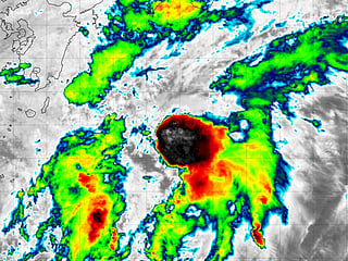 Twin storms force Japan to ground flights and warn of floods, landslides