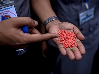 An official show pills of methamphetamine before seized illegal drugs are set on fire during a destruction ceremony to mark the United Nations' "International Day against Drug Abuse and Illicit Trafficking" in Yangon on June 26, 2026.