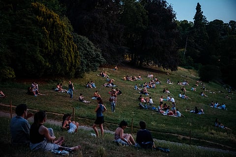 People sit on the grass to shelter from the heat in the Parc des Buttes-Chaumont in Paris, as France experiences a heatwave. Hundreds of Parisians seeking relief from the heat took refuge in the Parc des Buttes-Chaumont, in the north-east of the capital, which has remained open round the clock throughout the heatwave affecting France.