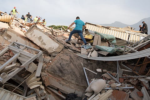 A volunteer makes his way through the rubble of a collapsed building following twin earthquakes in Caraballeda, La Guaira State, some 40 km northeast of Caracas, on June 25, 2026.