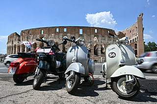 Vespa are parked near the Colosseum in Rome during the Vespa World Days marking the 80th anniversary of the iconic Italian brand of scooters on June 26, 2026.