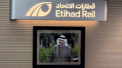A portrait of President His Highness Sheikh Mohamed bin Zayed Al Nahyan is displayed inside an Etihad Rail passenger train, reflecting the railway's connection to the UAE's national identity and leadership.