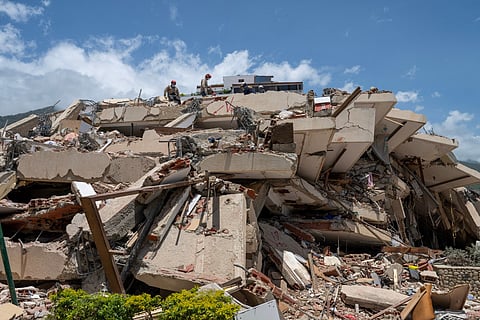 Argentine firefighters search for possible victims atop a collapsed building in Caraballeda, La Guaira state, Venezuela, on June 27, 2026, following twin earthquakes.