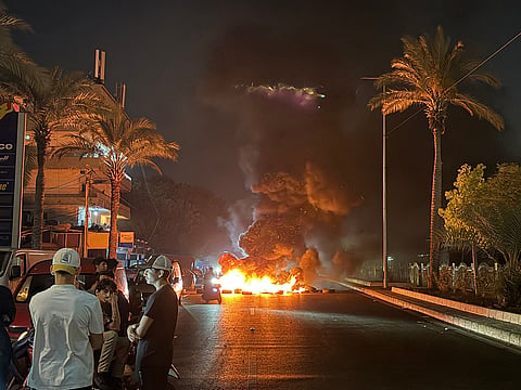 Hezbollah supporters block the old airport road in the southern suburbs of Beirut, with burning tires to protest against the trilateral agreement that was signed between the US, Israel and Lebanon on June 27, 2026. 