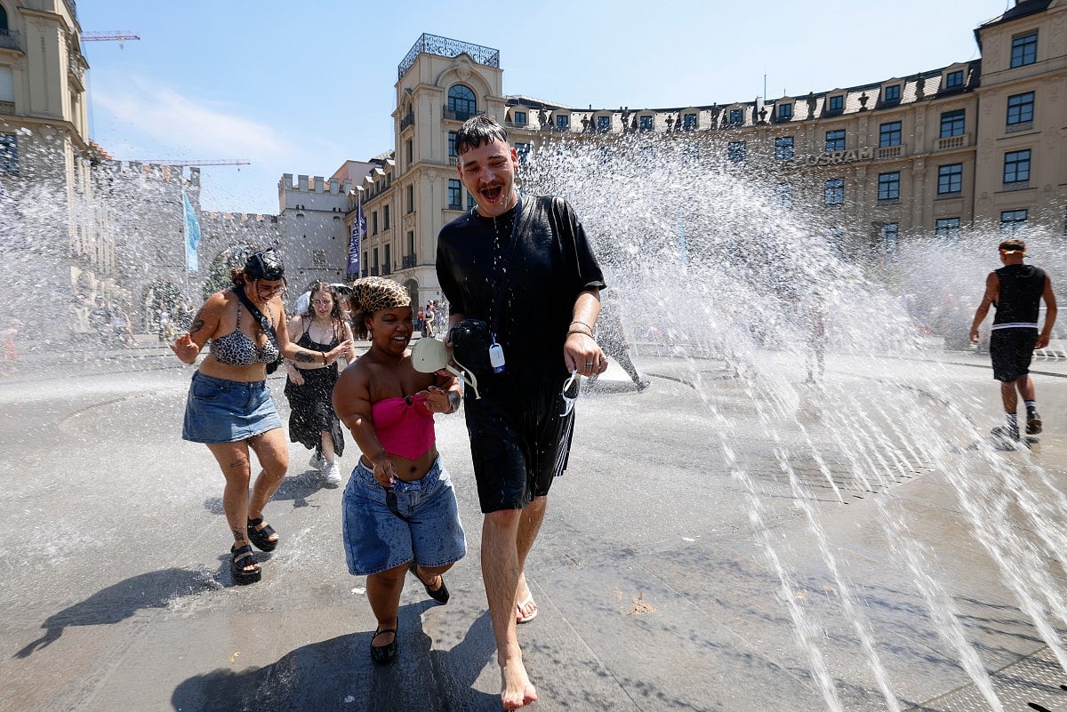 Participants of the Christopher Street Day (CSD) march cool down with water as temperatures went up to 36 degrees in Munich, southern Germany, on June 27, 2026.