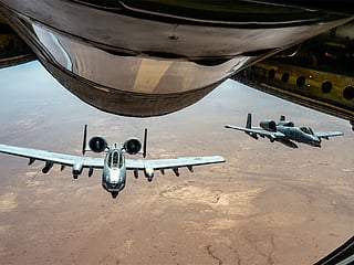 Two US Air Force A-10 attack aircraft fly together over the Middle East during a routine patrol. 