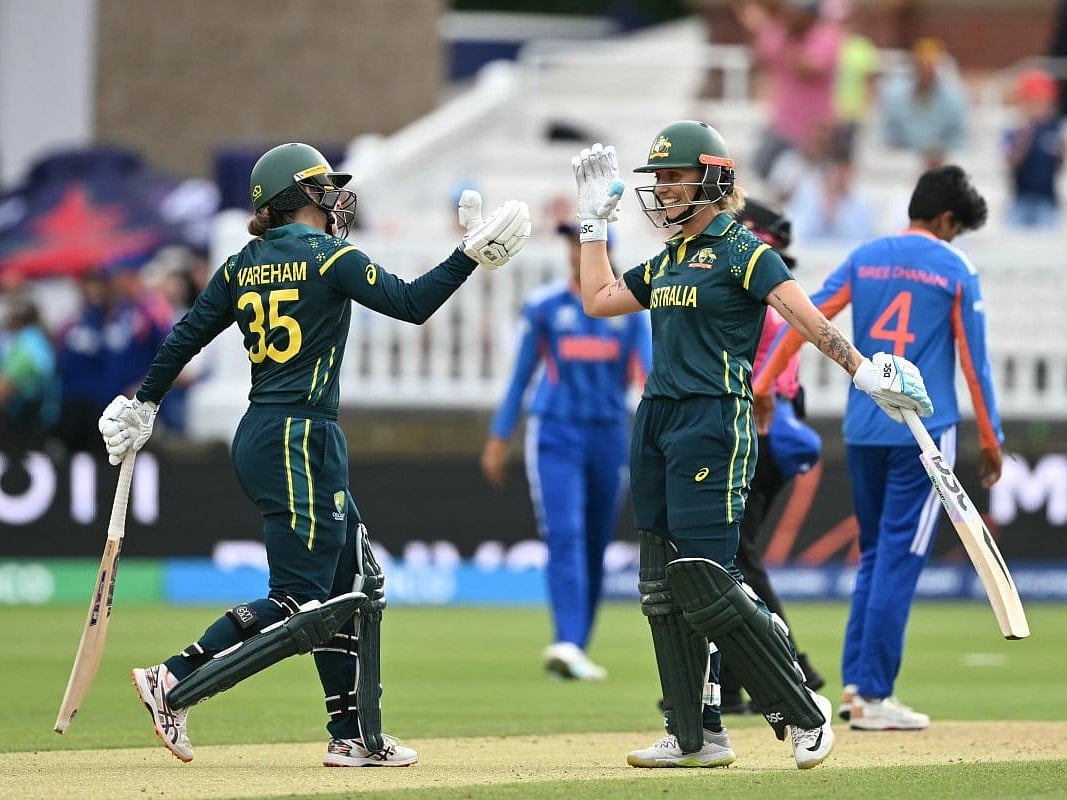 Australia's Georgia Wareham and Australia's Ashleigh Gardner celebrate after beating India 