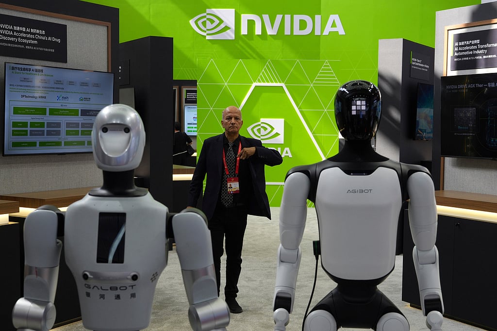 A worker stands near robots at the Nvidia booth during the China International Supply Chain Expo in Beijing on June 22, 2026. (AP Photo/Ng Han Guan)
