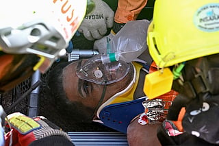 Hernan Gil, a survivor of Venezuela's twin earthquakes, is assisted by members of international rescue teams before being rushed into an ambulance in Catia La Mar, La Guaira State, Venezuela on July 2, 2026, eight days after the quake.