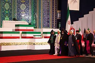 Local and foreign officials walk past the coffins of Iran's slain supreme leader Ali Khamenei and his family members after paying their respects at the Grand Mosalla in Tehran on July 3, 2026.