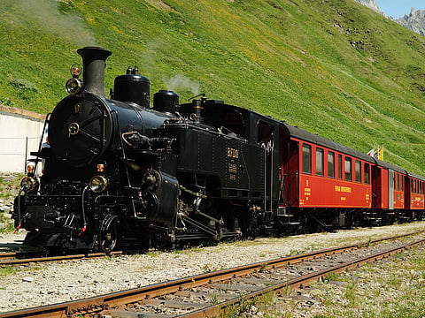 One of DFB's historic steam trains travels from Realp to Oberwald during a stop at the Furka station, Switzerland.