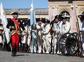 Re-enactors take part in a historical re-enactment to celebrate the 250th anniversary of the US' Declaration of Independence in the Grand Trianon garden at the Chateau de Versailles, in Versailles in the outskirts of Paris on July 4, 2026.