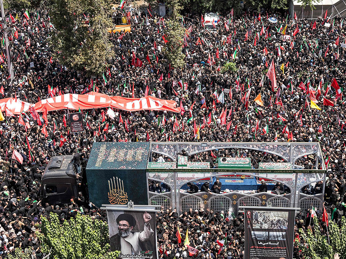 Crowds of mourners surround the convoy carrying the coffins of Iran's slain supreme leader Ali Khamenei and members of his family during a funeral procession near Azadi Square in Tehran on July 6, 2026.