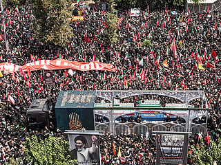 Crowds of mourners surround the convoy carrying the coffins of Iran's slain supreme leader Ali Khamenei and members of his family during a funeral procession near Azadi Square in Tehran on July 6, 2026. 