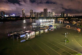 A flooded riverside walkway and shops are seen near a wharf on the Yongjiang river in Nanning, in China’s southern Guangxi region on July 6, 2026.