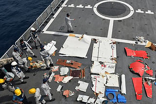 Pakistan Navy and Pakistan Maritime Security Agency personnel standing next to the wreckage of the K2 Airways Cargo Boeing 737.