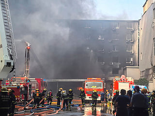 In this photo released by Xinhua News Agency, firefighters at the scene of a footwear factory fire in Jiangtou village, Chendai township of Jinjiang city, southeastern China's Fujian province, Thursday, July 9, 2026.  