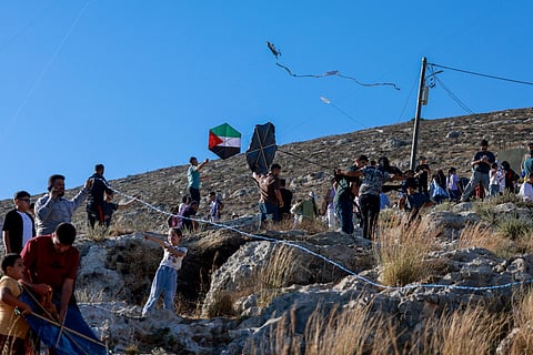 Palestinians and solidartiy activists fly kites towards the Israeli settelment of Har Bracha from the village of Burin, south of Nablus in the occupied West Bank on July 10, 2026.