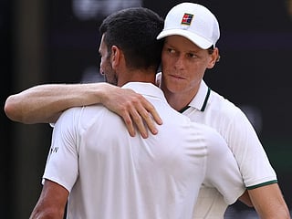 Italy's Jannik Sinner hugs Serbia's Novak Djokovic after winning the men's singles semi-final match of the 2026 Wimbledon Championships at The All England Lawn Tennis and Croquet Club in Wimbledon, southwest London, on July 10, 2026.