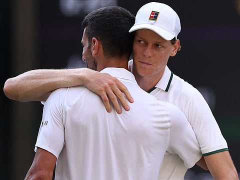 Italy's Jannik Sinner hugs Serbia's Novak Djokovic after winning the men's singles semi-final match of the 2026 Wimbledon Championships at The All England Lawn Tennis and Croquet Club in Wimbledon, southwest London, on July 10, 2026.