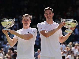 Britain's Henry Patten and Finland's Harri Heliovaara pose with their trophies after winning against El Salvador's Marcelo Arevalo and Croatia's Mate Pavic during their men's doubles final of the 2026 Wimbledon Championships at The All England Lawn Tennis and Croquet Club in Wimbledon, southwest London, on July 11, 2026.