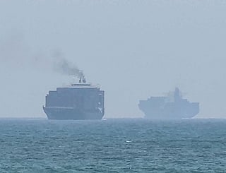Cargo ships anchoring near the Strait of Hormuz off the eastern coast of the United Arab Emirates at Khor Fakkan.