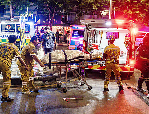 Emergency workers prepare to place the body of a victim into an ambulance after a fire at the Rong Beer Na Lat Phrao bar in Bangkok