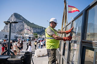 Against the backdrop of the Rock of Gibraltar, workers dismantle a Spanish border checkpoint that separated the disputed British overseas territory from Spain in La Línea de la Concepción, Spain, Monday, July 6, 2026.