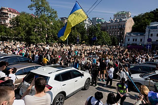 Protesters chant slogans and wave a Ukranian national flag as they take part in a demonstration against Ukraine's President Volodymyr Zelensky's decision to dismiss Ukraine's Defence Minister Mykhailo Fedorov, in Kyiv on July 16, 2026.