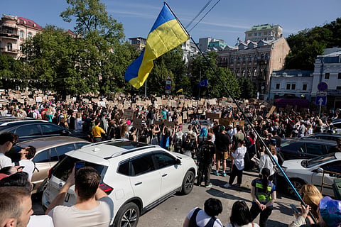 Protesters chant slogans and wave a Ukranian national flag as they take part in a demonstration against Ukraine's President Volodymyr Zelensky's decision to dismiss Ukraine's Defence Minister Mykhailo Fedorov, in Kyiv on July 16, 2026.