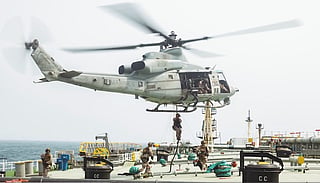 Marines fast-rope from a chopper onto the vessel's deck amid routine maritime security operations. The action comes amid heightened US-Iran tensions and ongoing military operations in the region. 