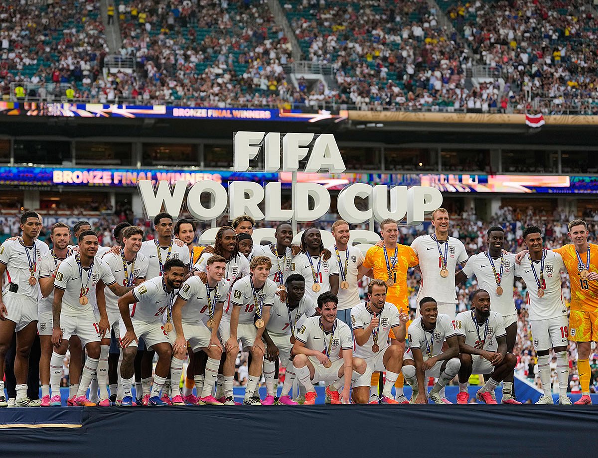 England's Harry Kane (9), front center, gives a thumbs as the team poses with their medals after the World Cup third-place playoff soccer match between France and England in Miami Gardens, Fla..