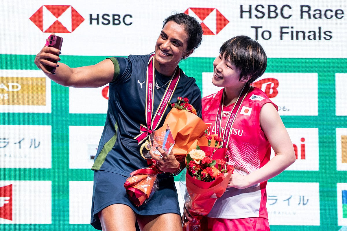 Gold medalist India’s Pusarla Venkata Sindhu (L) and silver medalist Japan’s Akane Yamaguchi take a selfie photo on the podium after their women's singles final match of the Japan Open badminton tournament at Tokyo Gymnasium in Tokyo on July 19, 2026.