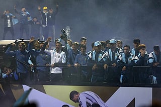 Argentina's head coach Lionel Scaloni (3-L) and members of Argentina's national football team wave aboard an open-top bus as they drive towards the Argentine Football Association (AFA) training camp in Ezeiza, Buenos Aires Province, on July 20, 2026, after returning from the United States following their defeat in the 2026 FIFA World Cup final.