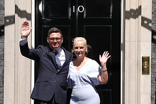 Britain's new Prime Minister Andy Burnham and his wife Marie-France van Heel wave as they arrive at 10 Downing Street in London, on Monday, July 20, 2026.