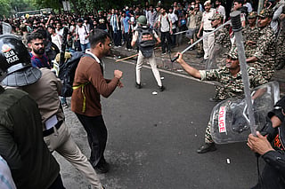 Central Reserve Police personnel baton-charge to disperse activists and supporters of the Cockroach Janta Party (CJP) during a protest demanding the resignation of India's Education Minister Dharmendra Pradhan over alleged NEET examination irregularities in New Delhi on July 20, 2026.