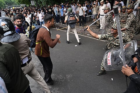 Central Reserve Police personnel baton-charge to disperse activists and supporters of the Cockroach Janta Party (CJP) during a protest demanding the resignation of India's Education Minister Dharmendra Pradhan over alleged NEET examination irregularities in New Delhi on July 20, 2026.