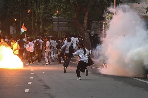 Rapid Action Force (RAF) personnel fire tear gas shells to disperse supporters of the Cockroach Janta Party (CJP) during a protest demanding the resignation of India's Education Minister Dharmendra Pradhan over alleged NEET exam irregularities in New Delhi on July 20, 2026.