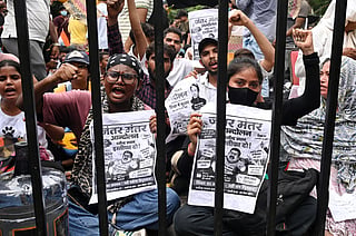 Protesters shout slogans as they carry posters asking for the resignation of India's Minister of Education Dharmendra Pradhan at a protest led by Cockroach Janta Party in New Delhi, India, Wednesday, July 22, 2026. (AP Photo/Vipin)