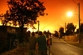 Residents look at the sky illuminated by wildfires in Le Porge, south-western France early on July 23, 2026.