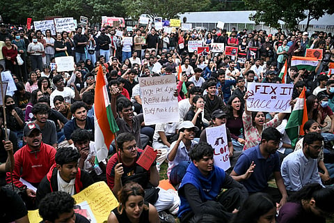 Demonstrators hold placards during a protest at Freedom Park in Bengaluru on July 22, 2026 in solidarity with the ongoing protest at New Delhi's Jantar Mantar demanding the resignation of India's Education Minister Dharmendra Pradhan over alleged NEET exam irregularities.