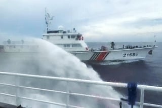 This handout screengrab taken on July 24, 2026 and released by the Philippine Coast Guard (PCG) shows a Chinese Coast Guard ship (back) firing water canon on a Philippine Bureau of Fisheries and Aquatic Resources (BFAR) ship near Scarborough Shoal, in the disputed South China Sea.