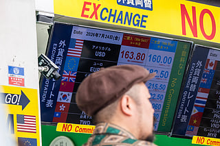 A man walks past a display showing currency rates at a money exchange in Shinjuku district in Tokyo on July 24, 2026.