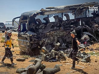 People and first responders inspecting the damage at the scene of the collision of two passenger buses on the Damascus-Deir Ezzor road between the Sukhna and Palmyra areas.