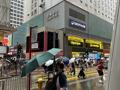 Passersby walk in Hong Kong's Mong Kok district under heavy rain and wind ahead of Typhoon Noul on Saturday, July 25, 2026. 