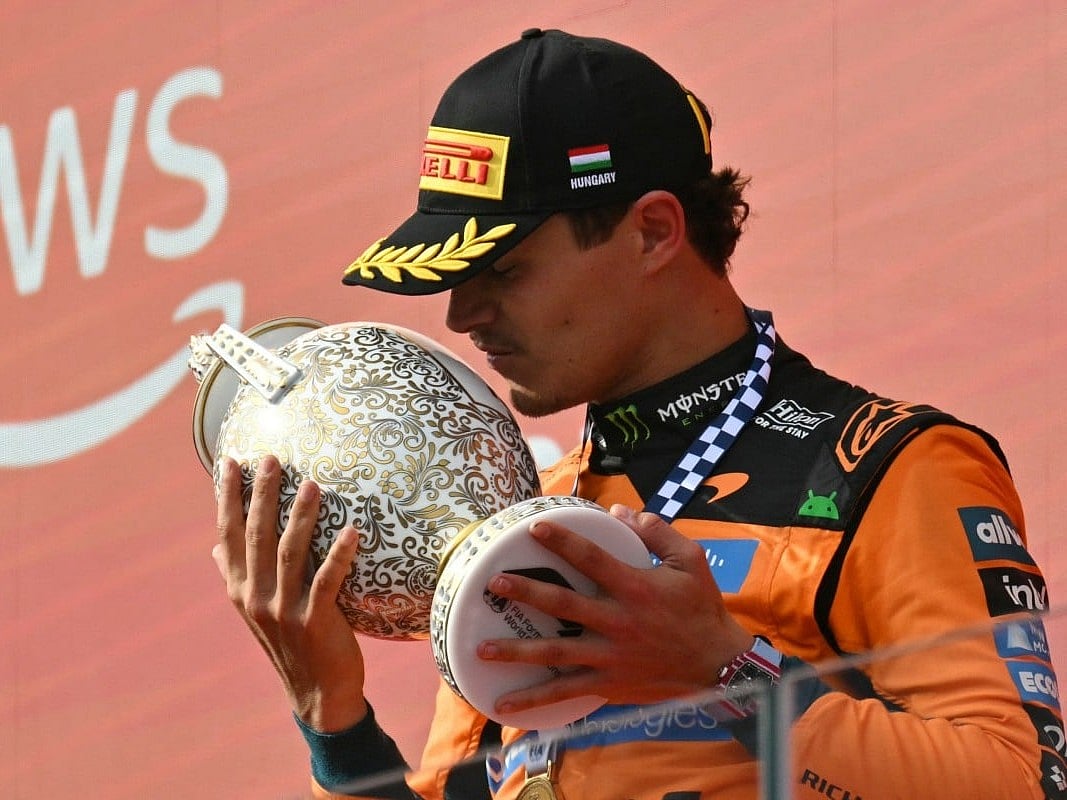 Winner McLaren's British driver Lando Norris kisses the trophy on the podium after the Formula One Hungarian Grand Prix at the Hungaroring racetrack in Mogyorod near Budapest, Hungary, on July 26, 2026.