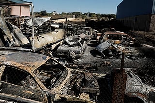 Burnt-out vehicles are seen in an industrial estate following a wildfire in Chapineria, 50 kilometers west of Madrid, on July 27, 2026