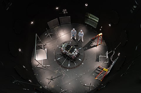 FILE - This photo provided by NASA shows Kieran Wilson, LINK's principal investigator, and Hunter Robertson, a space systems engineer, both at Katalyst Space, standing next to their spacecraft inside the SES (Space Environment Simulator) at NASA's Goddard Space Flight Center in Greenbelt, Md., April 17, 2026, ahead of thermal vacuum testing.