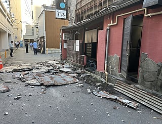 The exterior wall of a shop is seen collapsed in an earthquake, in Kumamoto City on July 28, 2026.