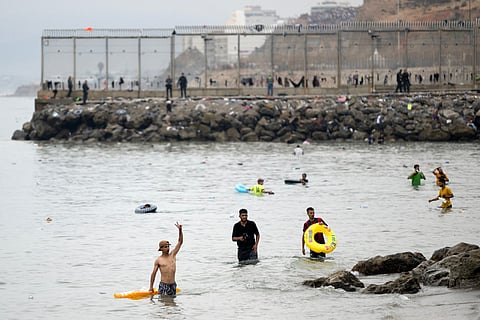 Migrants swim through the waters close to the border with Morocco to enter Spain's north Africa's Ceuta enclave.